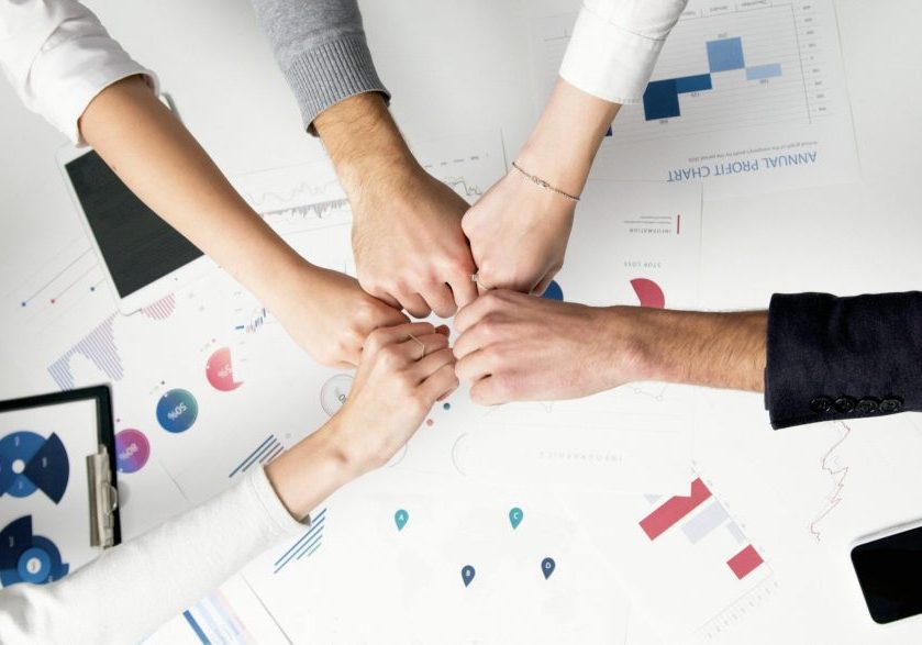 How-Smart-IT-Boosts-Employee-Morale-and-Keeps-Your-Best-People-scaled.jpg Free Colleagues celebrate success with a fist bump over financial charts depicting teamwork and unity. Stock Photo