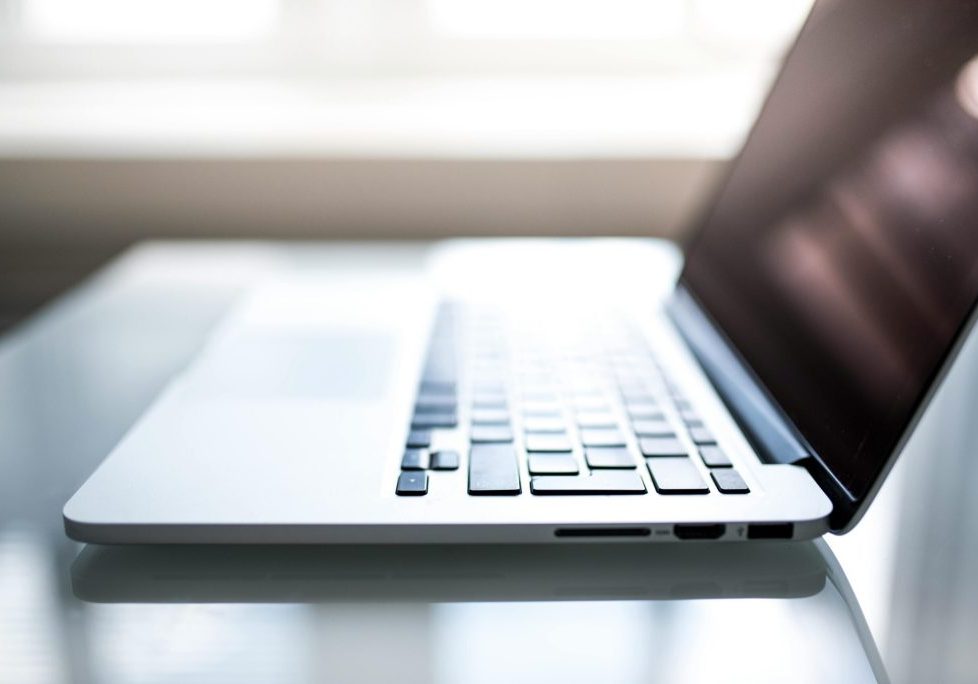 Free Elegant side view of a laptop on a glossy table with natural lighting indoors. Stock Photo
